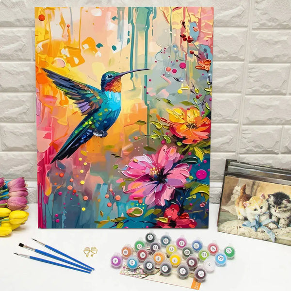 Pintura vibrante de un colibrí azul y verde sobre fondo floral colorido, junto a un pintar por números