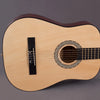 Guitare classique en bois clair avec finition brun foncé et rosette décorative sur la chevalet.
