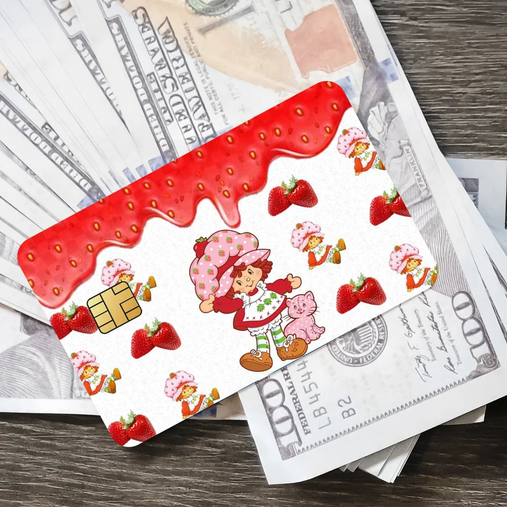 A sheet of cute strawberry and shortcake card stickers with a red drizzle design placed on top of paper money.