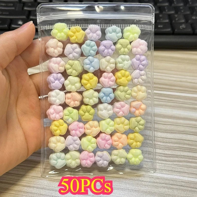 A clear plastic pouch filled with 50 pastel colored cat paw squishy stress relief fidget toys.