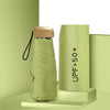 A light green compact 5-fold sun and rain umbrella standing upright on a pale green surface.