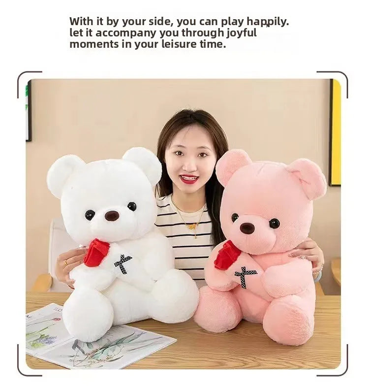 A white and pink plush bear gift set with a red rose design displayed on a wooden table.