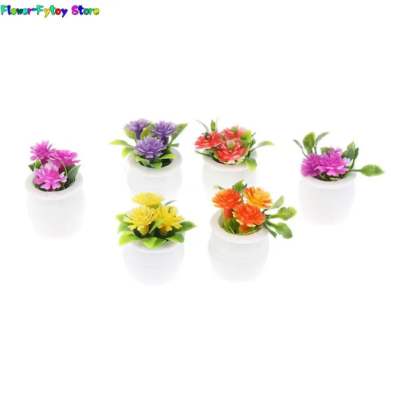 A collection of miniature green plant pots filled with colorful faux flowers for dollhouse decor.