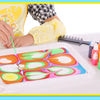 A child is using a paintbrush to apply colorful water marbling paint onto a silicone tray.