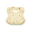 A beige soft silicone waterproof baby bib with an adjustable neck and small animal designs.