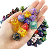A hand holds a collection of colorful polyhedral dice used for tabletop role-playing games