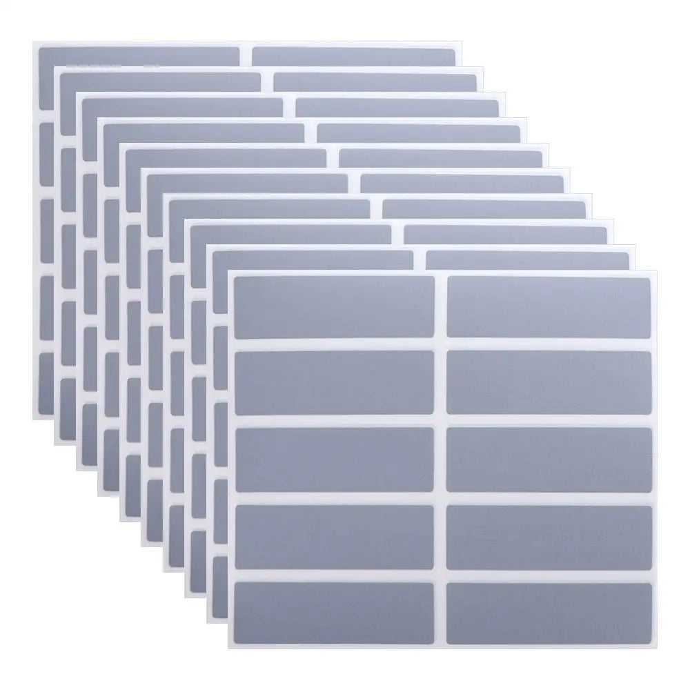 A stack of rectangular, translucent gray scratch-off sticker sheets arranged in a diagonal pattern.