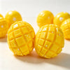 A close-up of bright yellow mango squishy stress relief balls with a crispy texture and small white dots.