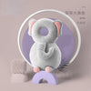A grey elephant plush toy is displayed next to a knitted item on a light pink background.
