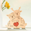 A wooden puzzle decoration featuring two elk figures with hearts and names Emma and William.