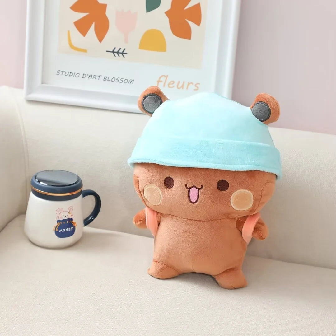A cute, light blue panda bear plush toy sitting on a white sofa next to a ceramic mug.