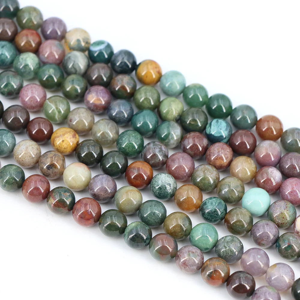 A string of round loose natural India agate beads in various shades of green, purple, and brown.