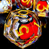 A close-up of a resin dice set with a spinning dragon eye core featuring red and black elements.