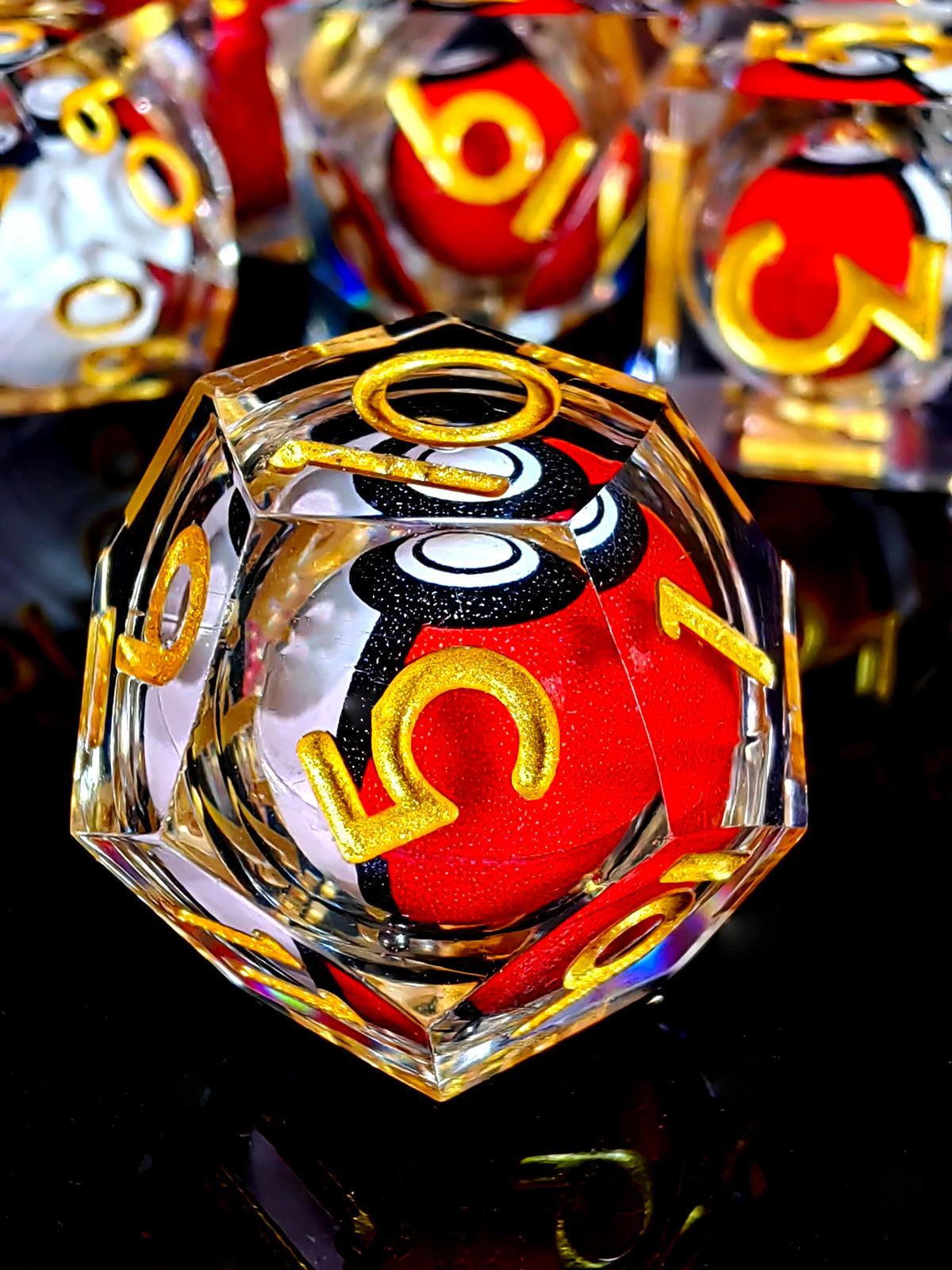 A close-up of a resin dice set with a spinning dragon eye core featuring red and black elements.