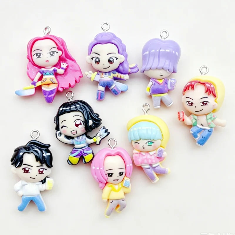 An assortment of eleven colorful cartoon resin pendant charms featuring various characters and hair colors.