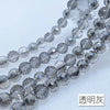 A close-up of a strand of clear and gray Austrian crystal beads with an AB coating
