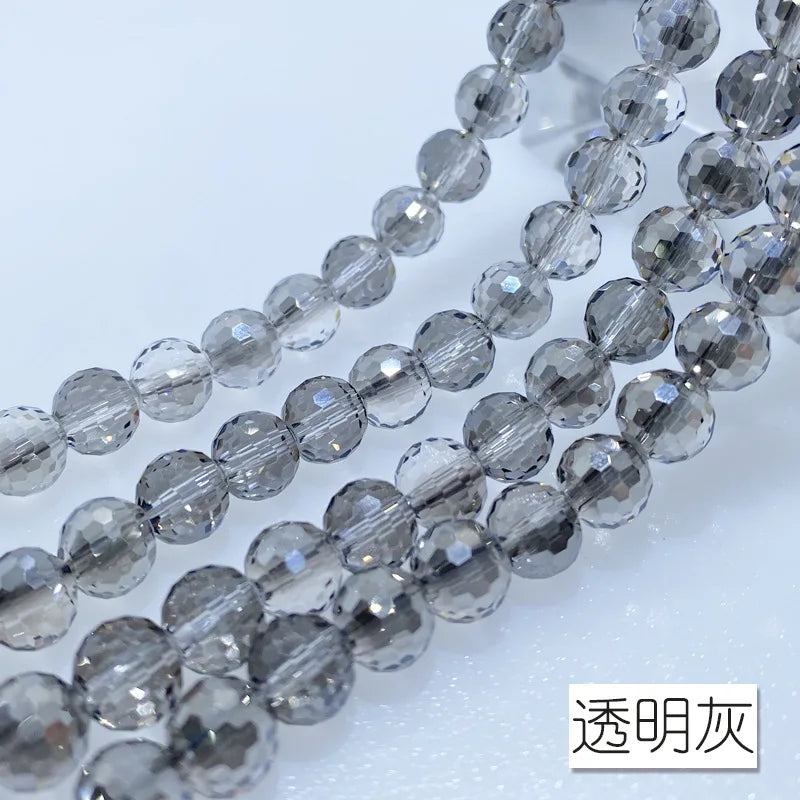 A close-up of a strand of clear and gray Austrian crystal beads with an AB coating