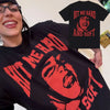 A woman wearing a black t-shirt featuring the text Hit Me Hard and Soft in red print.