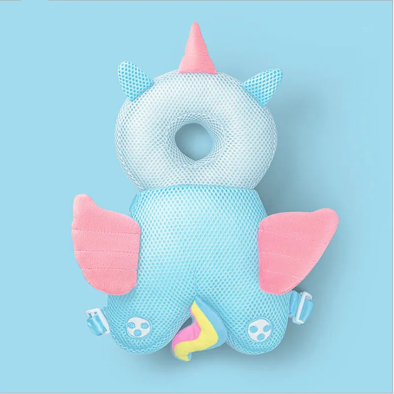 A light blue soft baby head protector pillow shaped like a dinosaur with pink wings and adjustable straps.