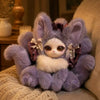 A fluffy purple fox plush collectible with white accents sitting on a beige sofa next to a lamp.