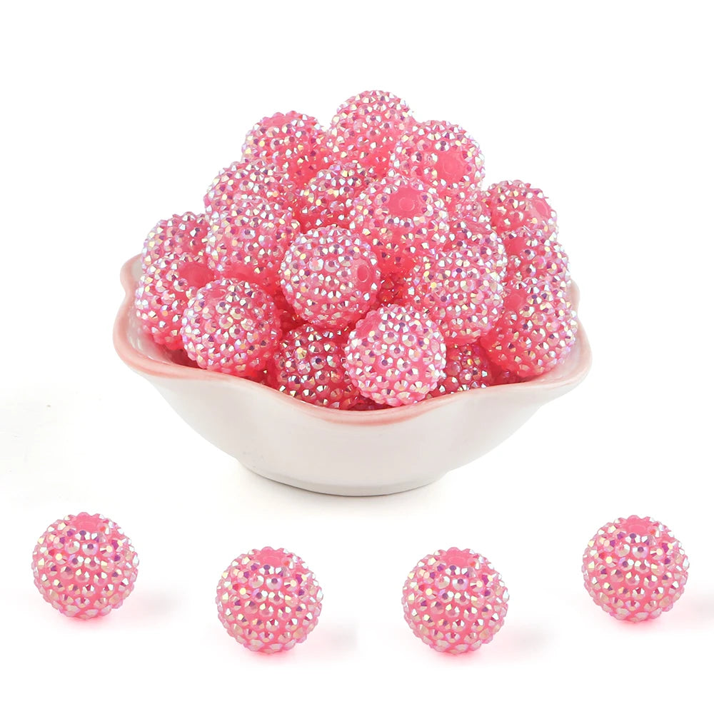 A pile of pink and clear rhinestone resin bayberry beads for jewelry making.