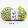 A ball of multi-colored yarn, featuring shades of green, yellow, and purple, labeled as Zime Jane cotton yarn.