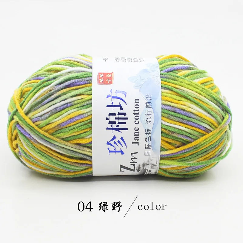 A ball of multi-colored yarn, featuring shades of green, yellow, and purple, labeled as Zime Jane cotton yarn.