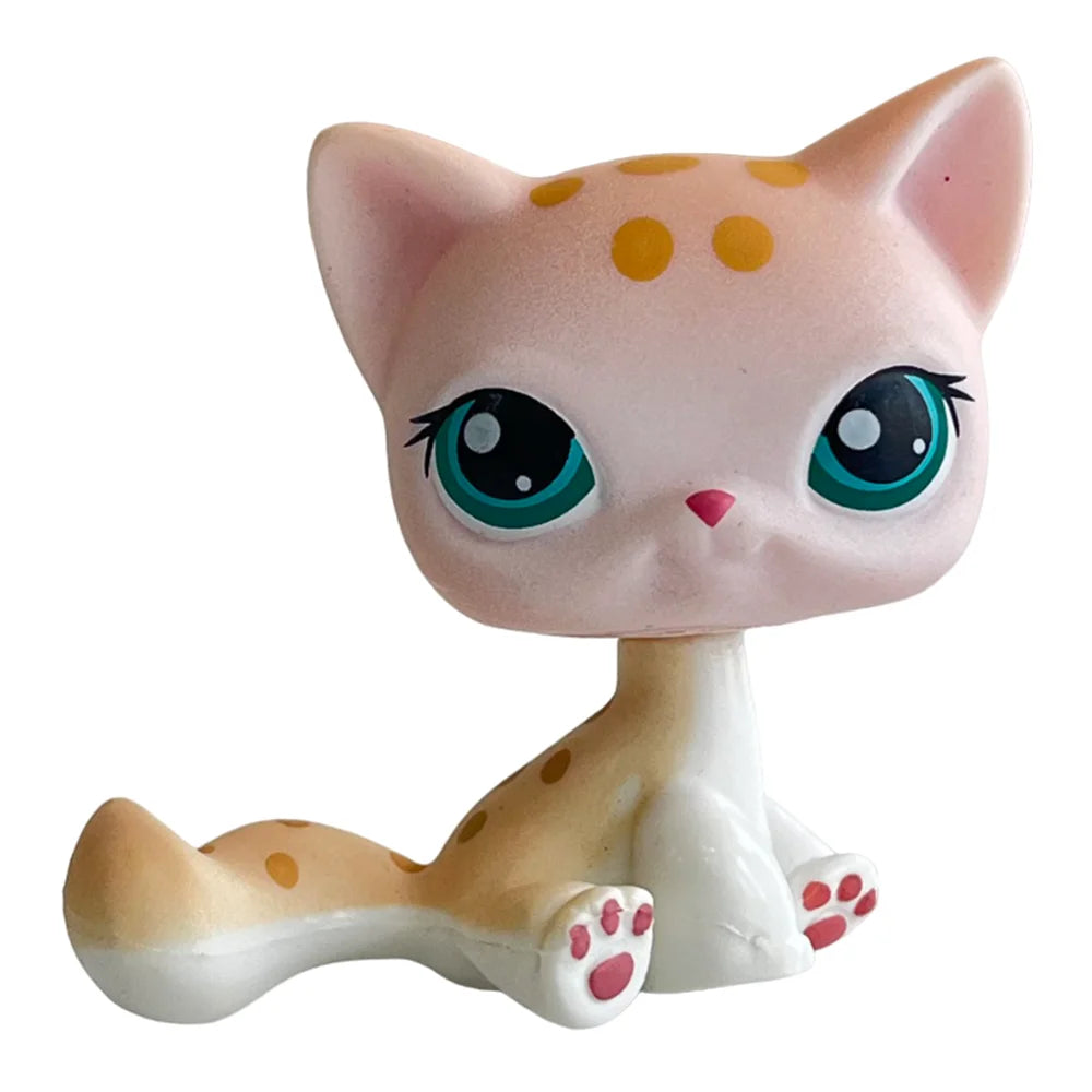 A pink and white cat bobble head figurine with large green eyes and orange spots.