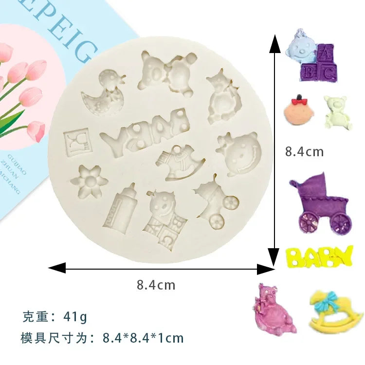A set of silicone baby-themed cake molds including a stroller, bottle, pacifier, and other shapes.