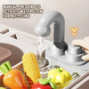 A faucet is shown dispensing water into a plastic tray filled with pretend vegetables like corn, tomatoes, and squash.