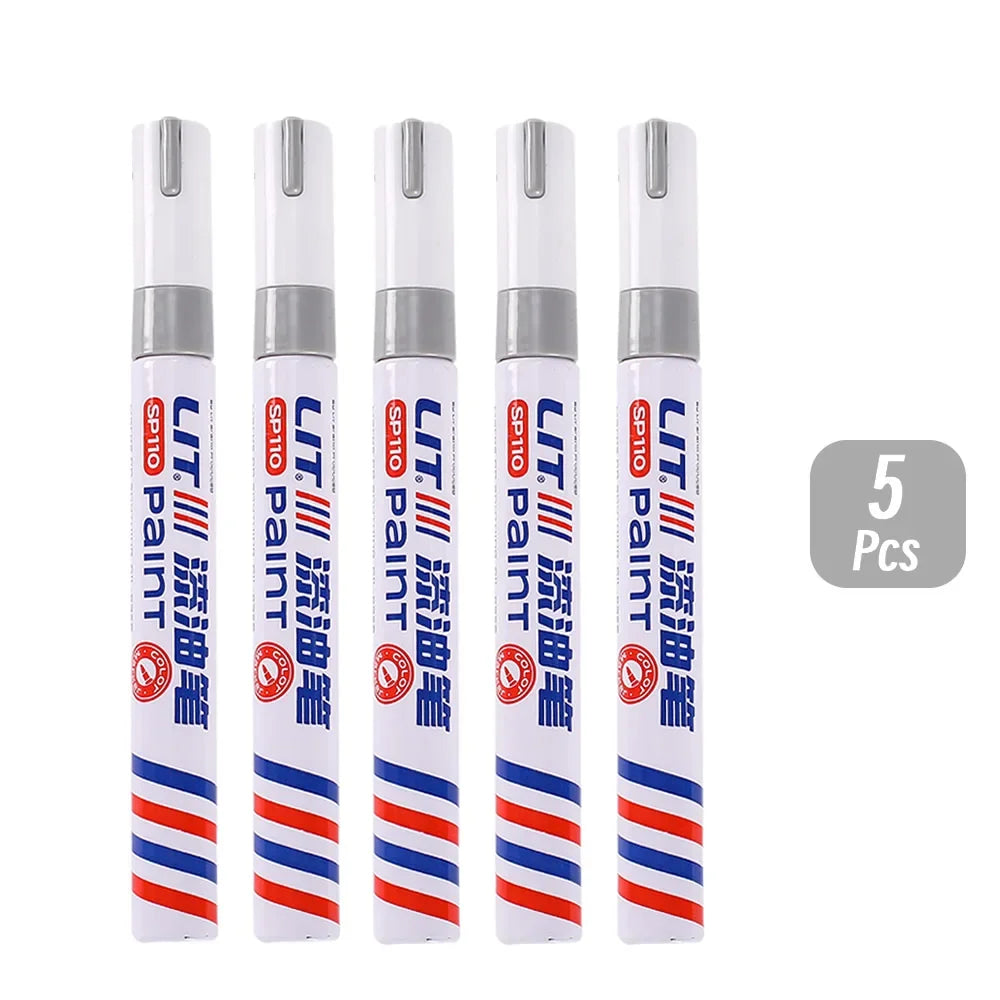 Five permanent paint markers in white and blue with red accents, packaged for rubber, fabric, and metal painting.