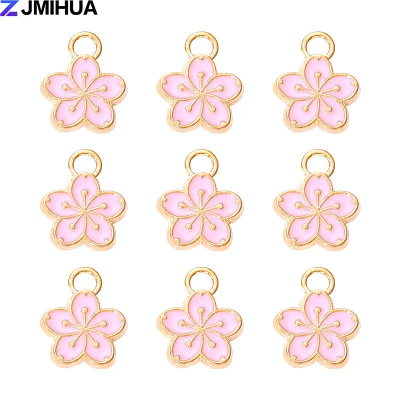 A set of 15 enamel flower and cherry charms for jewelry making in pink and gold.
