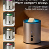 A silver electric wax melt heater with a blue glow is shown on a wooden surface.