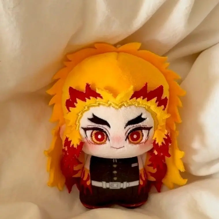 A cute anime plush doll featuring bright yellow hair with orange and red accents and large eyes.