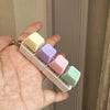 A hand holds a fidget keychain stress reliever with multiple colorful, clickable keys.