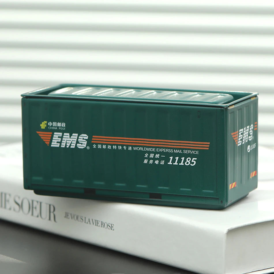 A dark green industrial storage box for EMS mail service with Chinese text and contact information resting on a white book.