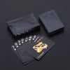 A stack of elegant black and gold waterproof playing cards next to a dark rectangular box.