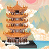A detailed model of the Yellow Crane Tower built from micro building blocks, set against a soft, mountainous landscape.