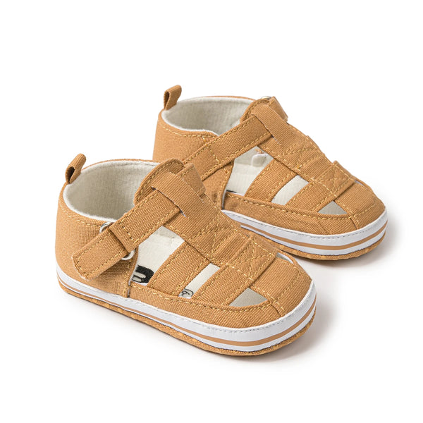A pair of tan breathable canvas sandals for baby and toddler, shown from the side.