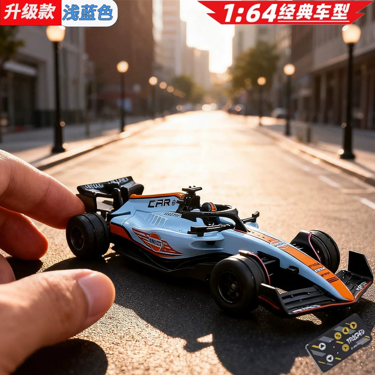 A hand holds a blue and orange 1:64 scale alloy RC drift car on an asphalt road.