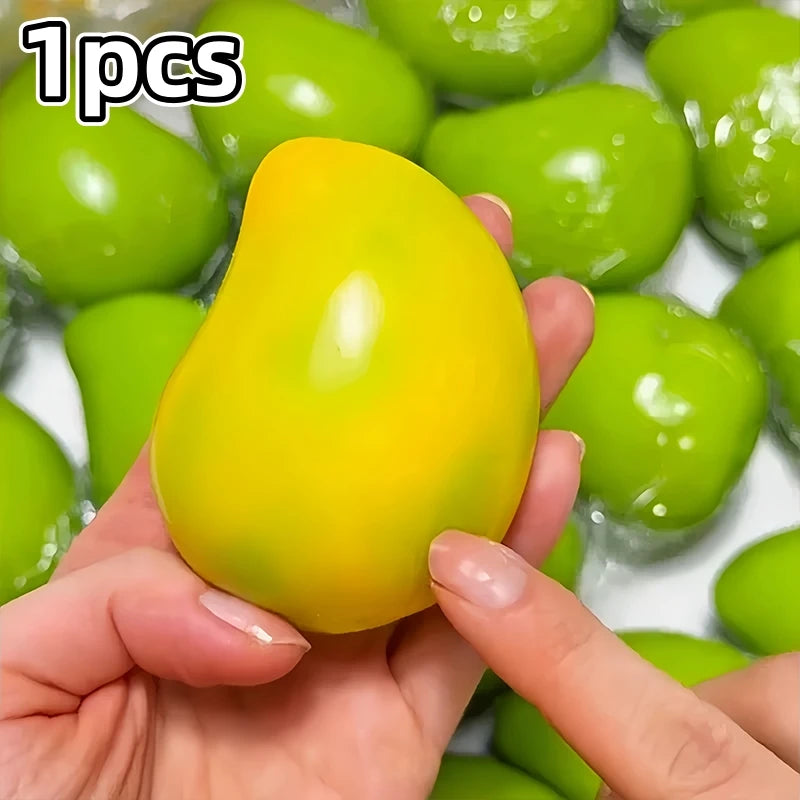A hand holds a bright yellow color-changing mango squishy stress ball surrounded by green ones.