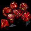 A collection of red resin dice, including d20s and d12s, scattered on a dark surface.