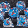 A collection of translucent blue dice with red markings scattered on a dark surface.
