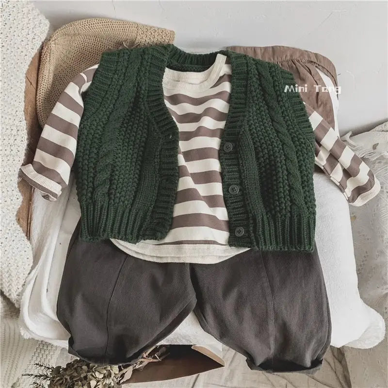 A stack of olive green knitted cardigan and dark gray pants for boys
