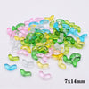 A pile of colorful glass beads in various shades of green, pink, and blue.