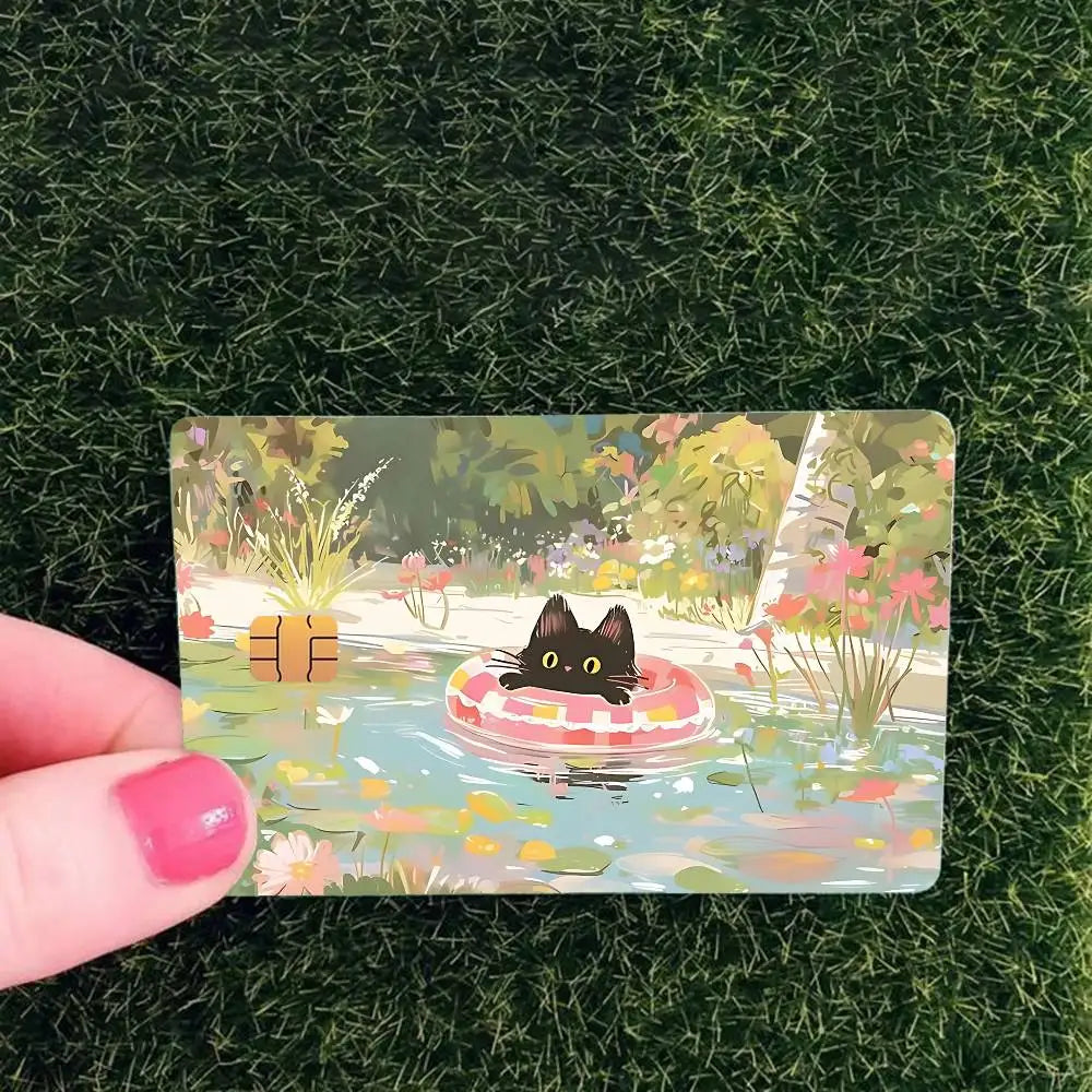 A card featuring a cute black cat floating in water surrounded by colorful flowers and foliage.