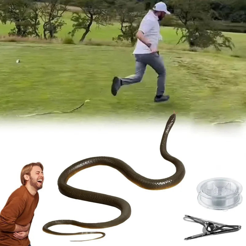 A realistic snake prank toy with a string and clip is shown against a grassy background.