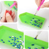 A set of diamond painting tools featuring an ergonomic drill pen used to apply blue and silver sequins onto a green tray.