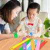 A child is using colorful felt button bracelets for fine motor skill development on a wooden table.