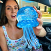 A woman holds a translucent blue jellyfish squish toy with flowing tentacles.
